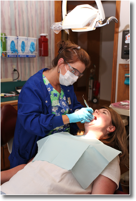 a hygienist cleans a patient's teeth