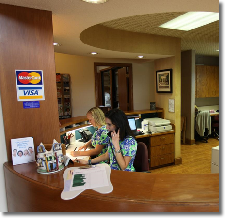 two young women work at the reception desk at Erwin Dental