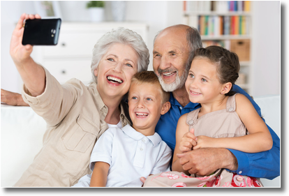 grandparents and their grandchildren take a photograph of themselves with a cell phone